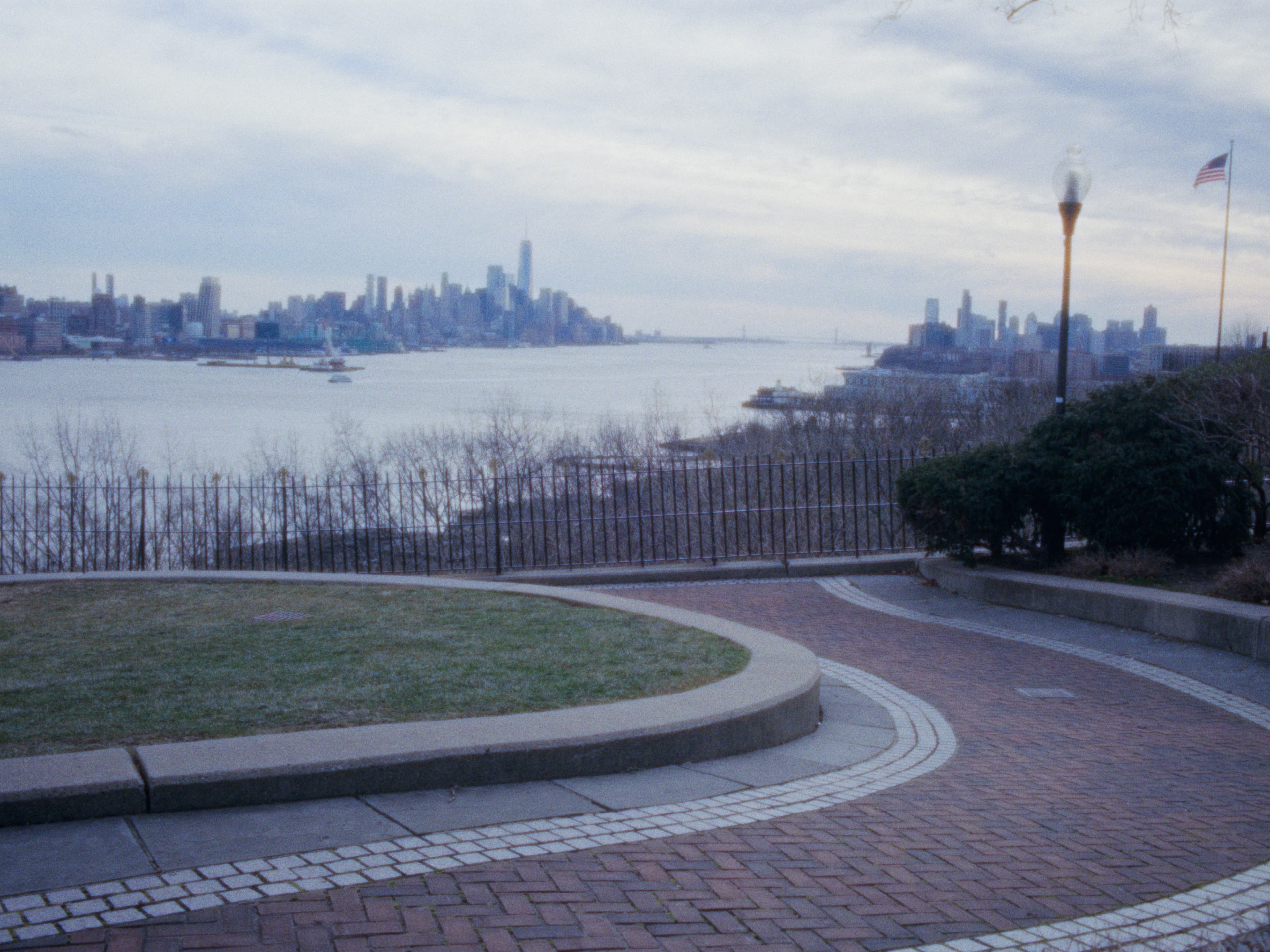 An overlook and skyline across the water under a cloudy sky.