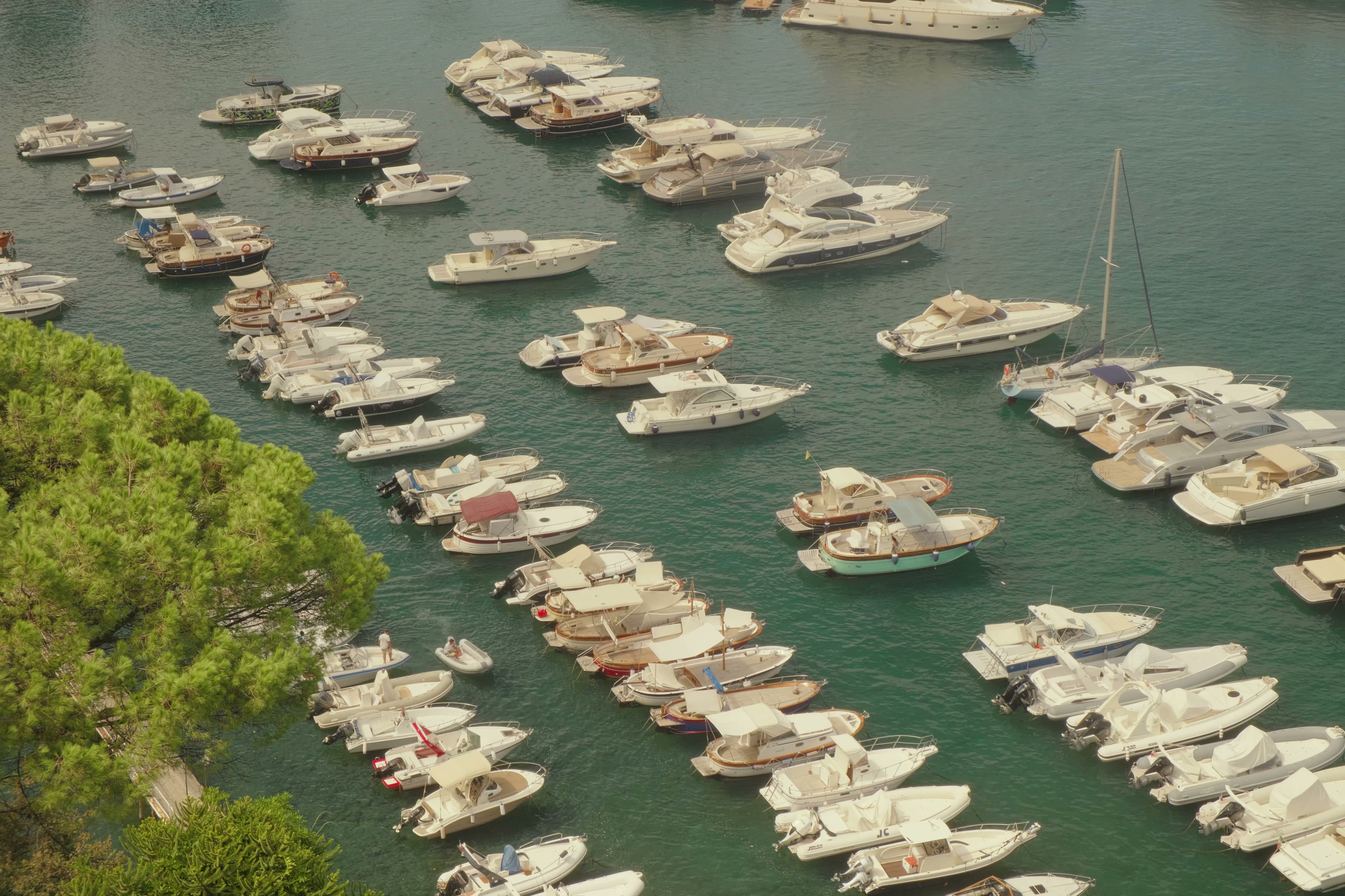 Aerial view of a Mediterranean marina packed with white boats.