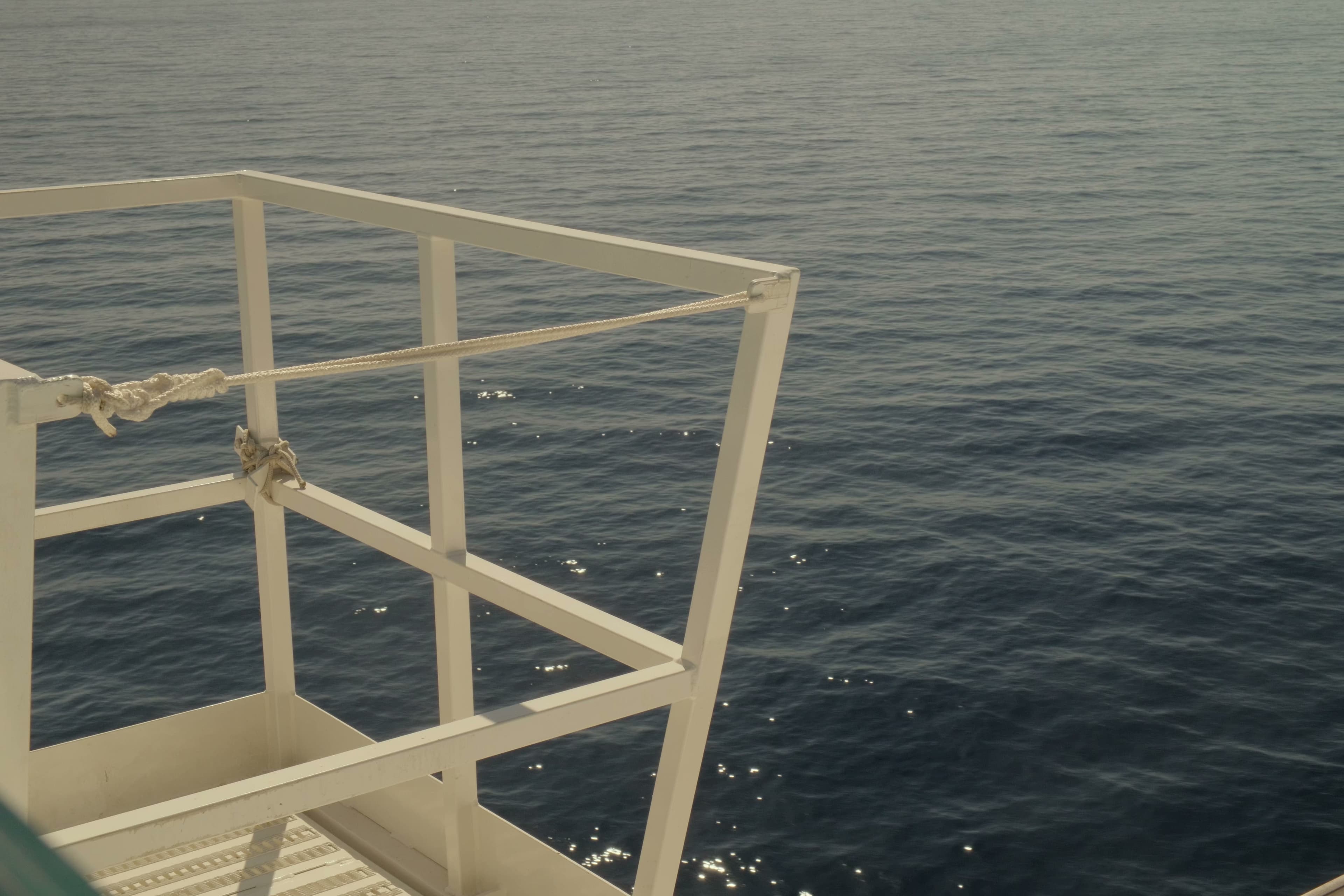 White metal railing overlooking the deep blue Mediterranean Sea.