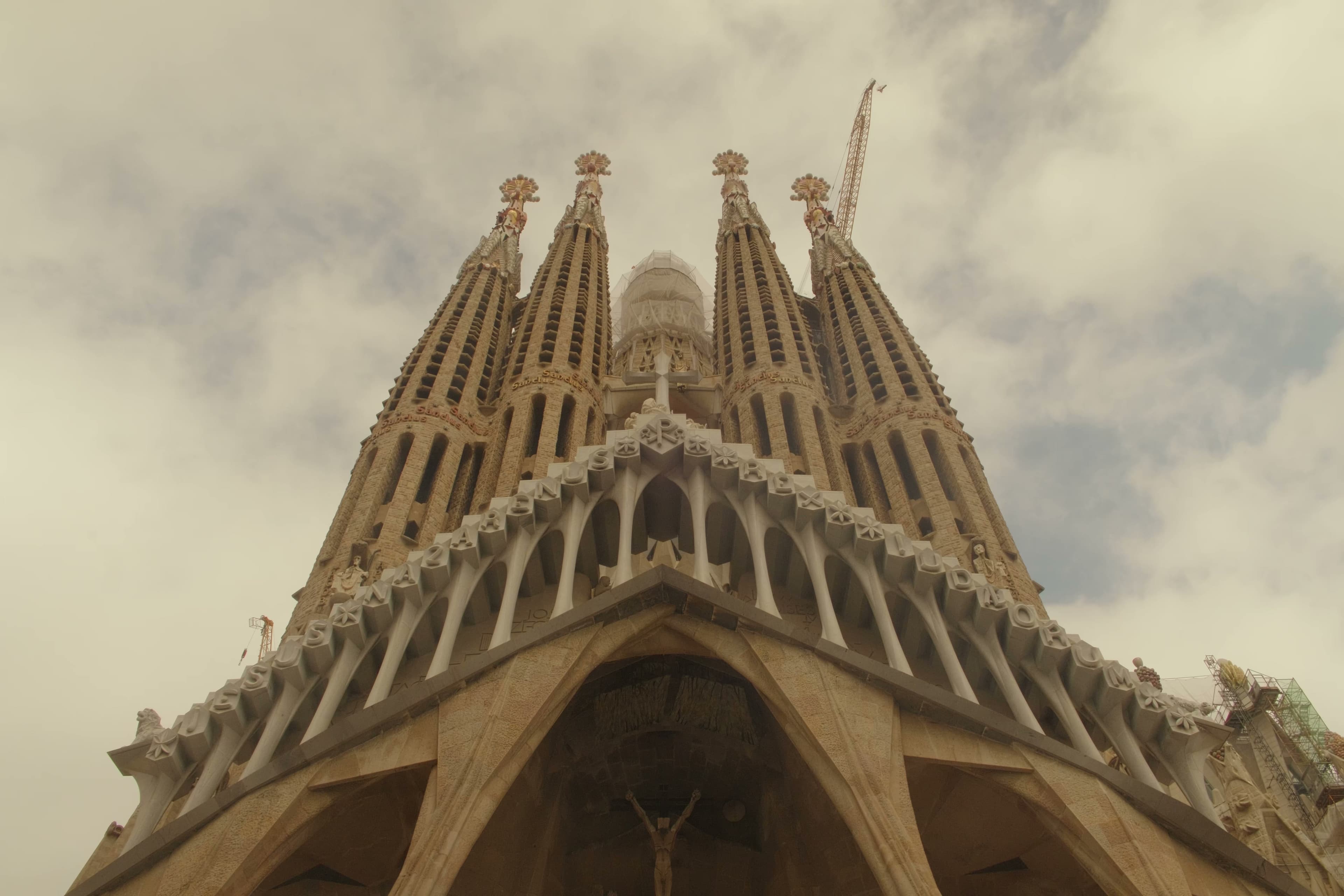 The towering spires of Sagrada Familia against an overcast sky.
