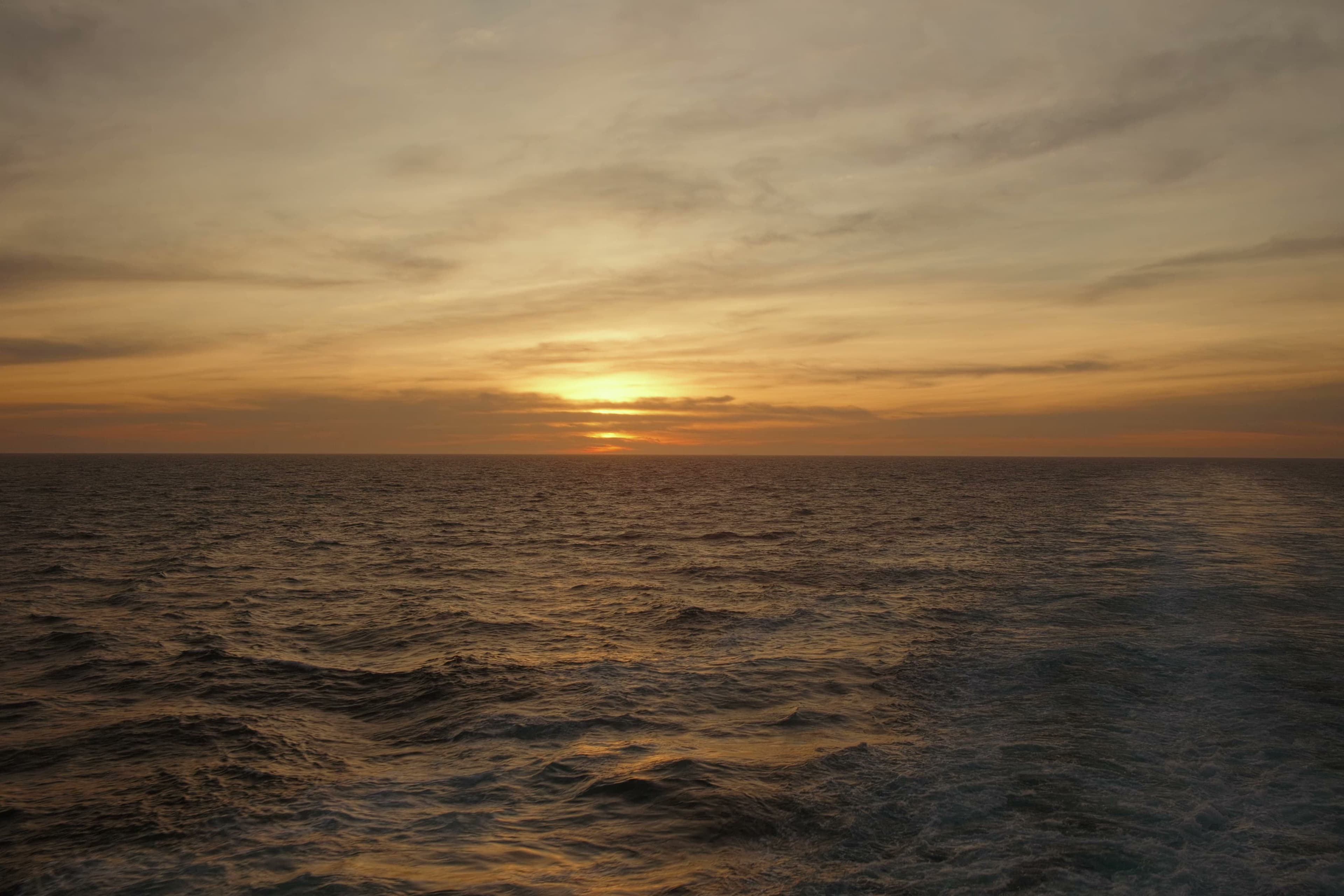 Golden sunset over the Mediterranean Sea with textured waves.