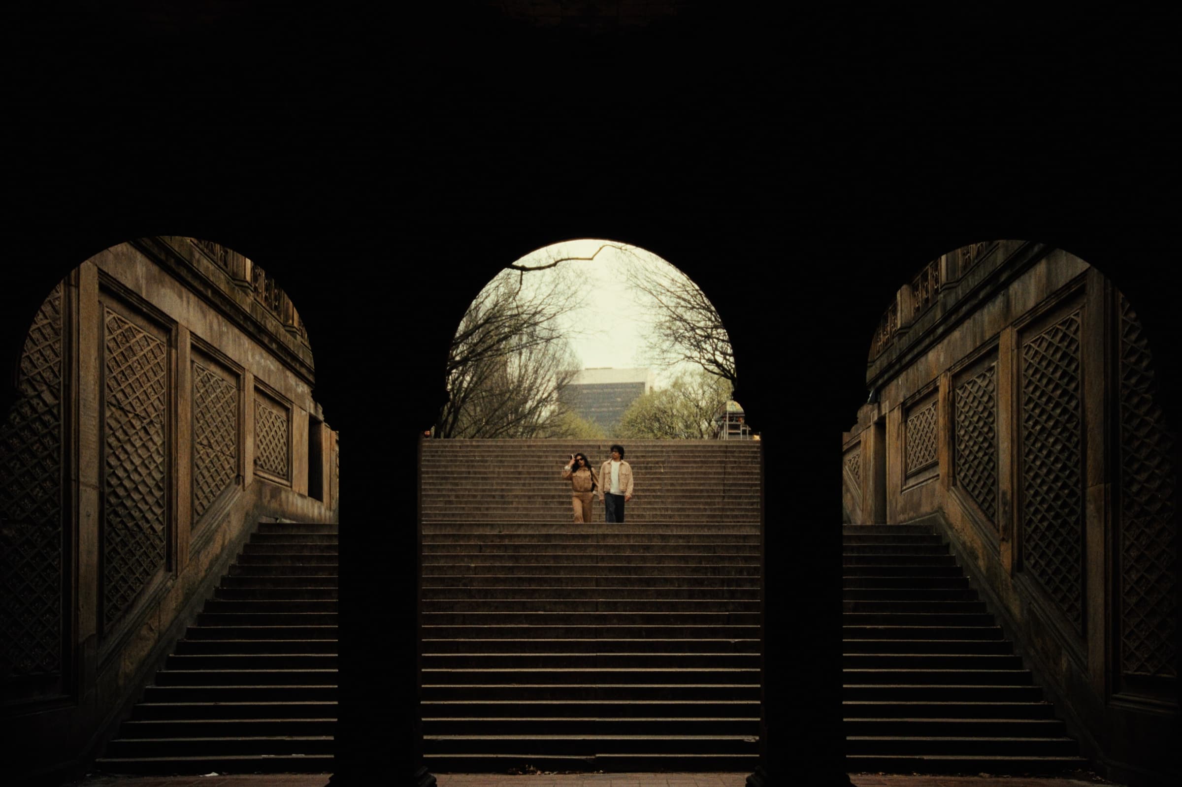 Andrew Amisola — Andrew and Jackie framed by the central archway of Bethesda Terrace, ascending stone steps into diffused light